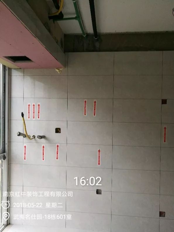 南京武夷名仕園124平米簡(jiǎn)美風(fēng)格裝修  享受家?guī)?lái)的溫度30五月份_墻磚鋪貼完成后，紅牛裝飾的工人會(huì)用專用護(hù)角條對(duì)瓷磚角保護(hù)，用標(biāo)貼標(biāo)出水管、線管走向示意。